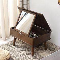 an open wooden jewelry box sitting on top of a rug next to a white wall