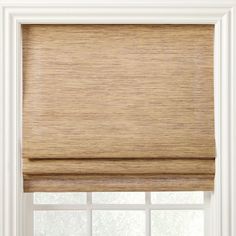 a tan roman blind in front of a window with the blinds pulled back to reveal an off - white background