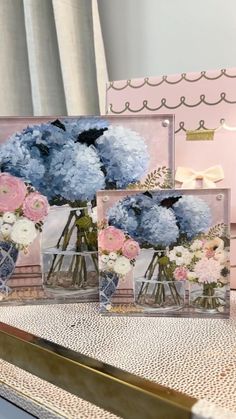 three vases filled with blue and pink flowers