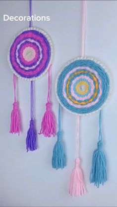 three colorful handmade dream catchers hanging on a white wall with tassels