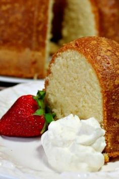 a bundt cake with whipped cream and a strawberry on the plate next to it