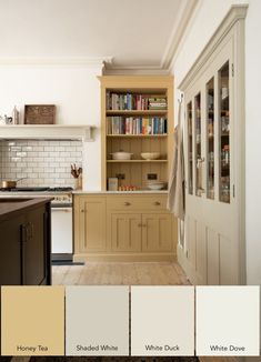 a kitchen with beige cabinets and white walls