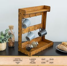 a wooden shelf with coffee cups on it next to a plate and potted plant