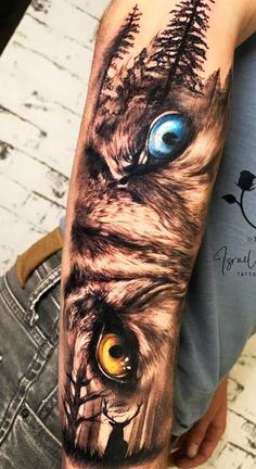 a man's arm with an owl and tree tattoo on it