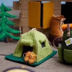 two small houses made out of felt and some little shoes on the floor next to each other