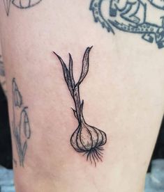 a close up of a person's leg with tattoos on it and a onion