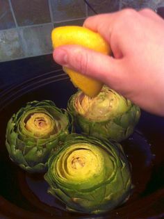 someone is peeling an artichoke into small pieces with a lemon in the middle