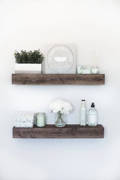 two wooden shelves with flowers and candles on them