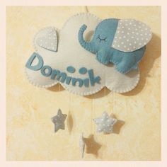 a baby mobile with an elephant and stars hanging from it's side on a wall