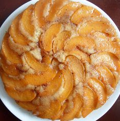 a white plate topped with sliced peaches on top of a table