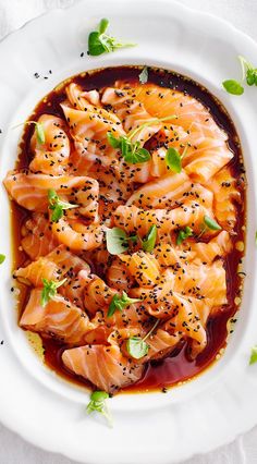 a white plate topped with pasta covered in sauce and garnished with parsley