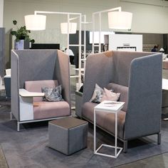 two chairs and a table on display in a room with other furniture items around them