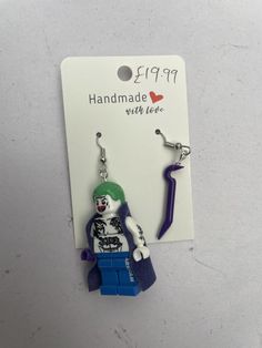 a pair of earrings with a lego figure hanging from it