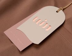 a tag that is on the side of a brown suit with pink trimmings