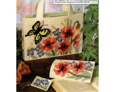 a book with an image of flowers and butterflies on it, next to a purse