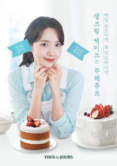 a woman sitting at a table with two cakes and fruit on the plate in front of her