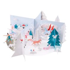 an open book with paper cut out of people and animals in the snow next to trees