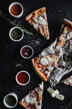 several slices of pizza with different toppings on the table