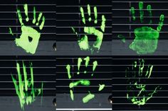 green handprints on the blinds of a window in front of a black background