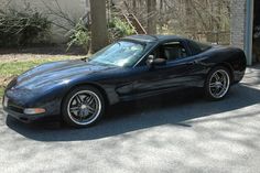 a black sports car parked in front of a garage