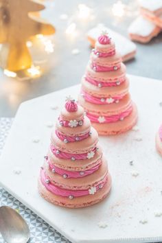 pink frosted cupcakes are arranged in the shape of a christmas tree on a plate