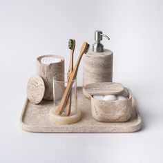 a bathroom set consisting of soap, toothbrushes and toiletries on a tray