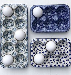 three trays filled with white eggs on top of a table