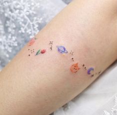 a woman's arm with small tattoos on it