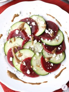 a white plate topped with cucumber and radishes covered in feta cheese