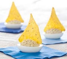 three small bowls filled with food sitting on top of a blue cloth next to each other