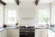 a kitchen with white cabinets, black counter tops and an oven in the center area