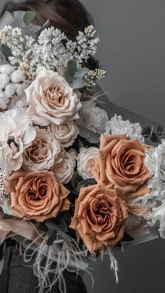 a bouquet of white and peach flowers with feathers