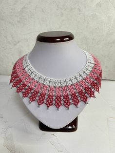 a red and white beaded necklace on a mannequin