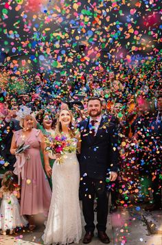 the newly married couple are surrounded by confetti