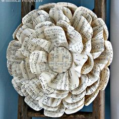 an old ladder with sheet music as the focal point for this wreath made out of book pages