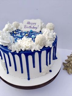 a birthday cake with blue and white icing on it sitting on a platter