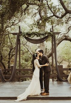 a bride and groom kissing in front of an outdoor ceremony