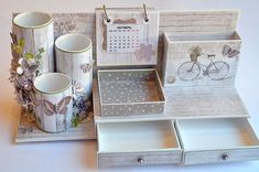 a set of drawers with cups, mugs and calendars on them sitting next to each other