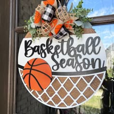 a basketball season door hanger hanging on the front door of a house with an orange and black wreath