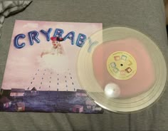 a person holding a clear vinyl record in their left hand with the word crybab on it