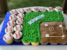 a baseball themed birthday cake with cupcakes in the shape of a field and ball