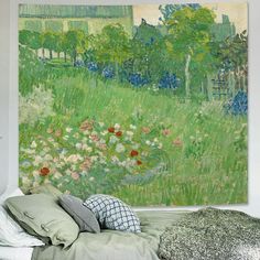 a painting on the wall above a bed with pillows and blankets in front of it