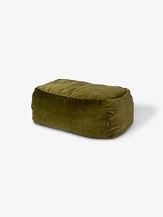 a green bean bag sitting on top of a white floor