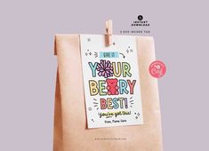 a brown paper bag with the words your berry best on it and a pink flower