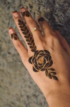 a woman's hand with hennap on it and a rose tattooed on the palm