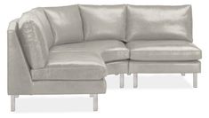 a gray leather sectional sofa sitting on top of a white floor