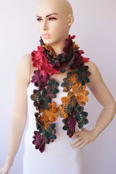 a mannequin wearing a multicolored crocheted scarf with flowers on it