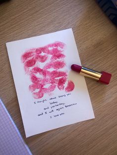 a red lipstick sitting on top of a piece of paper