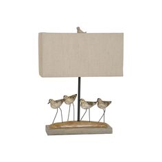 three little birds sitting on the base of a lamp with a linen shade over it