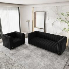 two black couches sitting next to each other on a rug in a living room